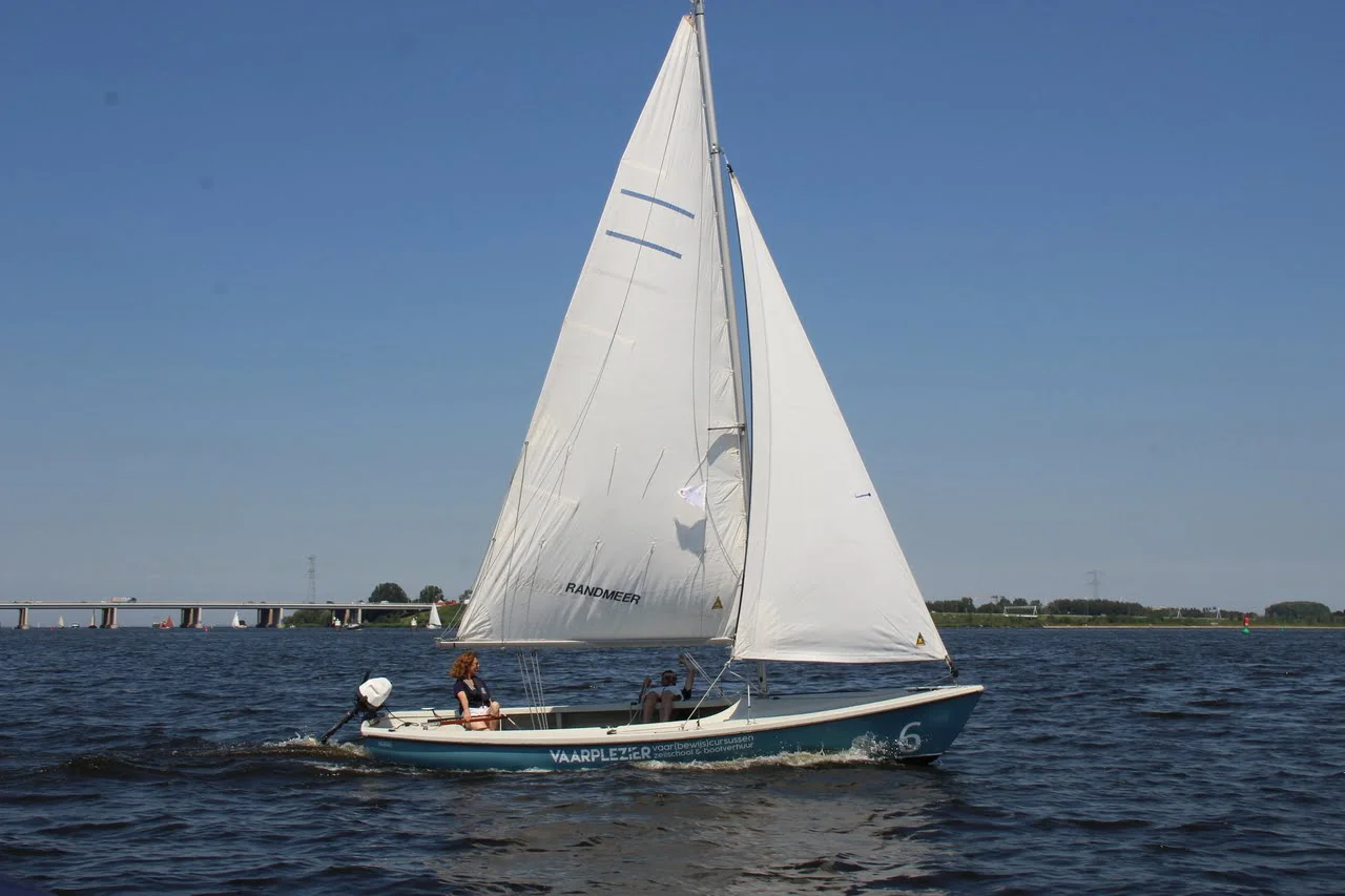 Lichtblauwe Randmeer zeilboot van Vaarplezier varend met witte zeilen op het Randmeer