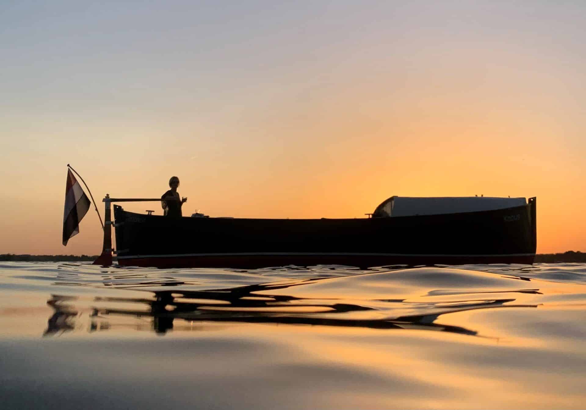 Boot in het water met zonsondergang op de achtergrond