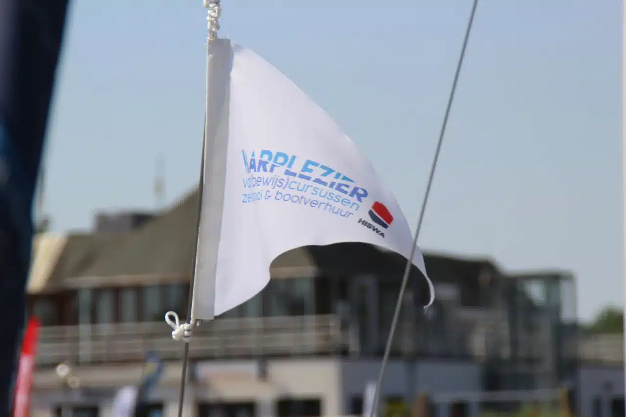 Vlag met Vaarplezier op Randmeer zeilboot van de Vaarplezier Zeilschool in de Jachthaven Naarden