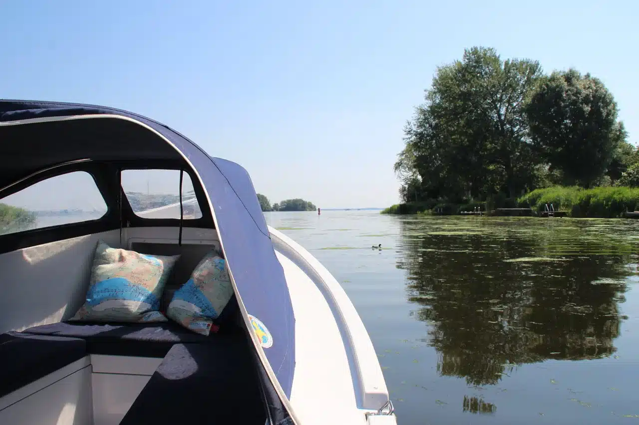 Klein Vaarbewijs 1 nodig voor waterscooter die over rivier vaart met een man en een vrouw die reddingsvesten dragen